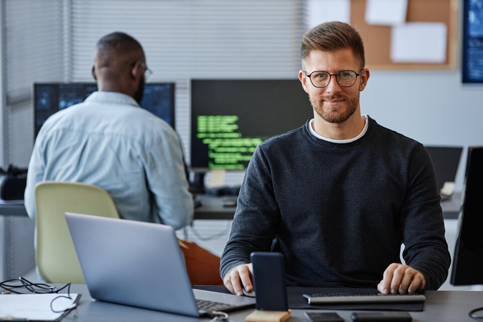 20230615004008_[fpdl.in]_portrait-male-software-developer-smiling-camera-while-sitting-workplace-office-copy-spac_236854-44706_large